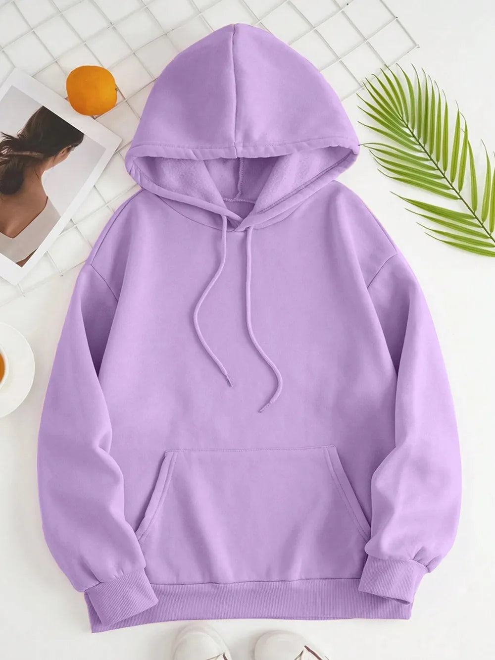 Purple hoodie on a white background with a leaf and orange in the corner